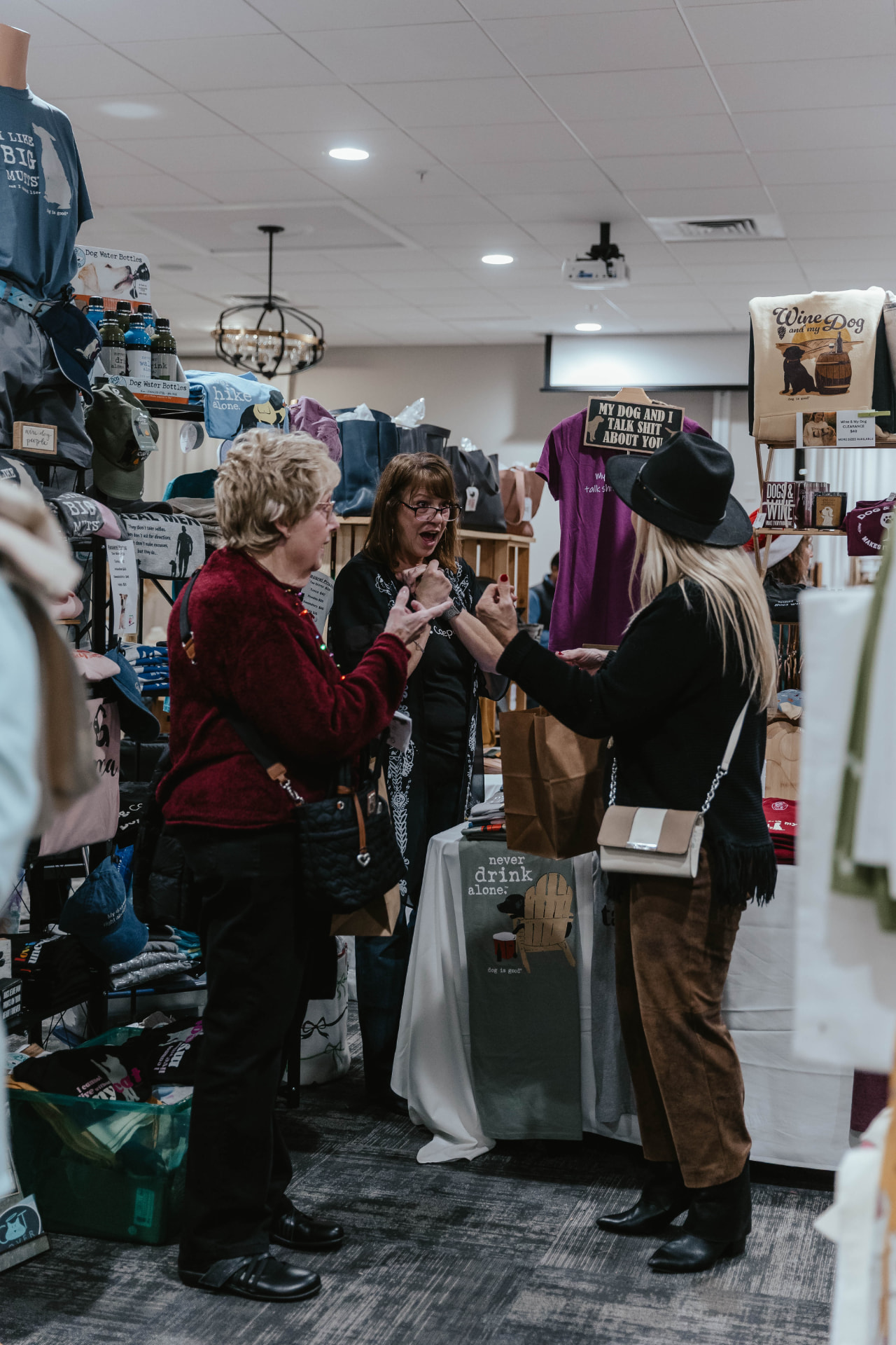 Guests visiting a vendor booth at the Sip & Sparkle Vendor Holiday Market.