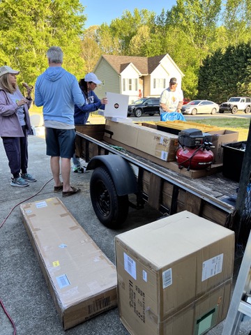 Volunteers unloading boxed furnishings and transformation supplies.