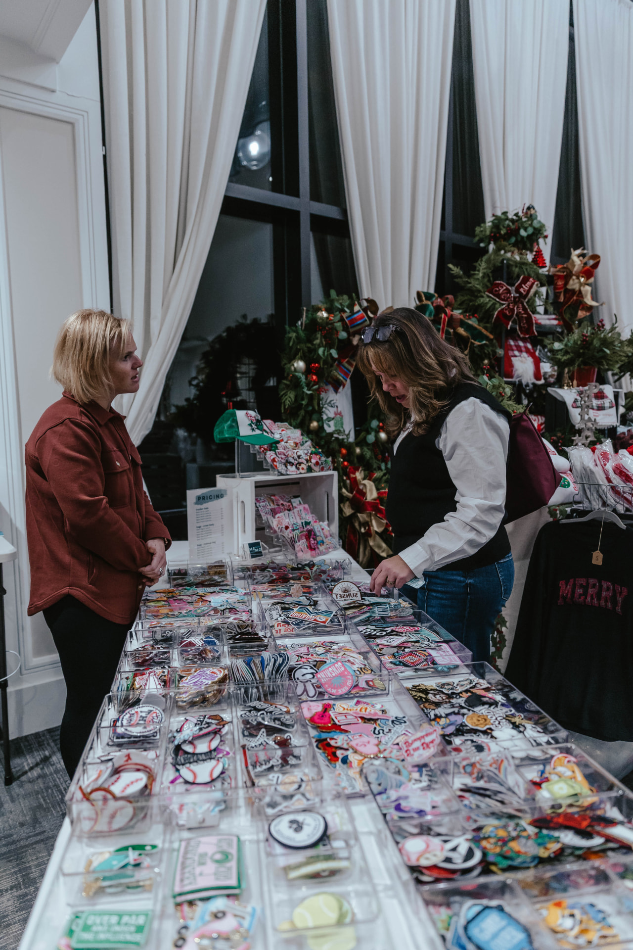 Guest browsing stickers and small gifts at the Sip & Sparkle Vendor Holiday Market.