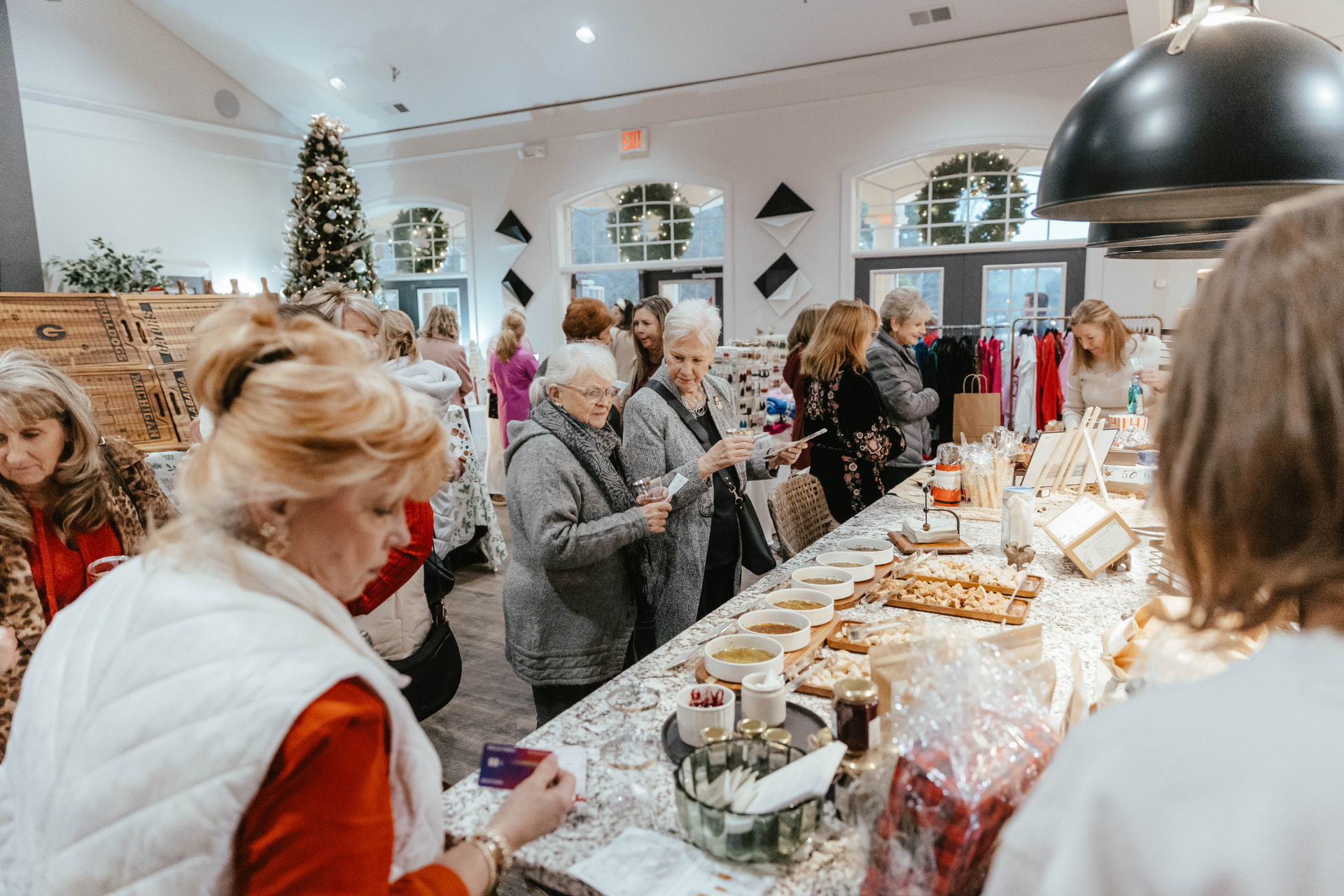 Guests browsing vendor tables at the Sip & Sparkle Vendor Holiday Market.