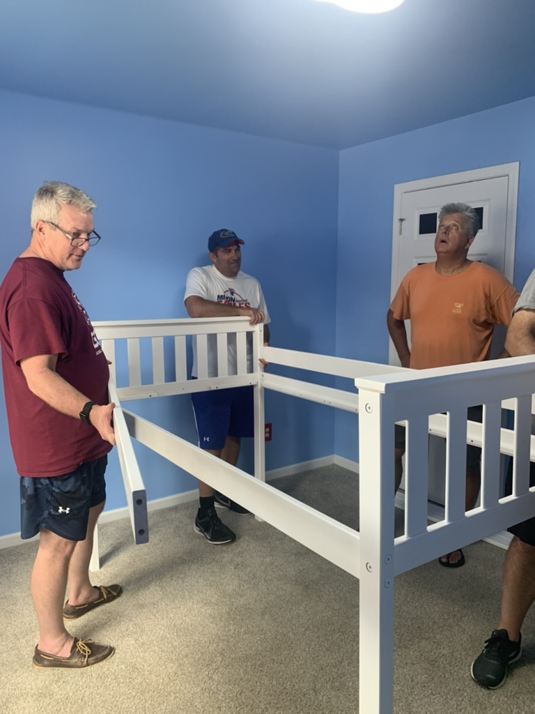 Volunteers assembling a new blue bed.