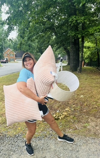 RRGA volunteer carrying bedding and lighting materials during a transformation.