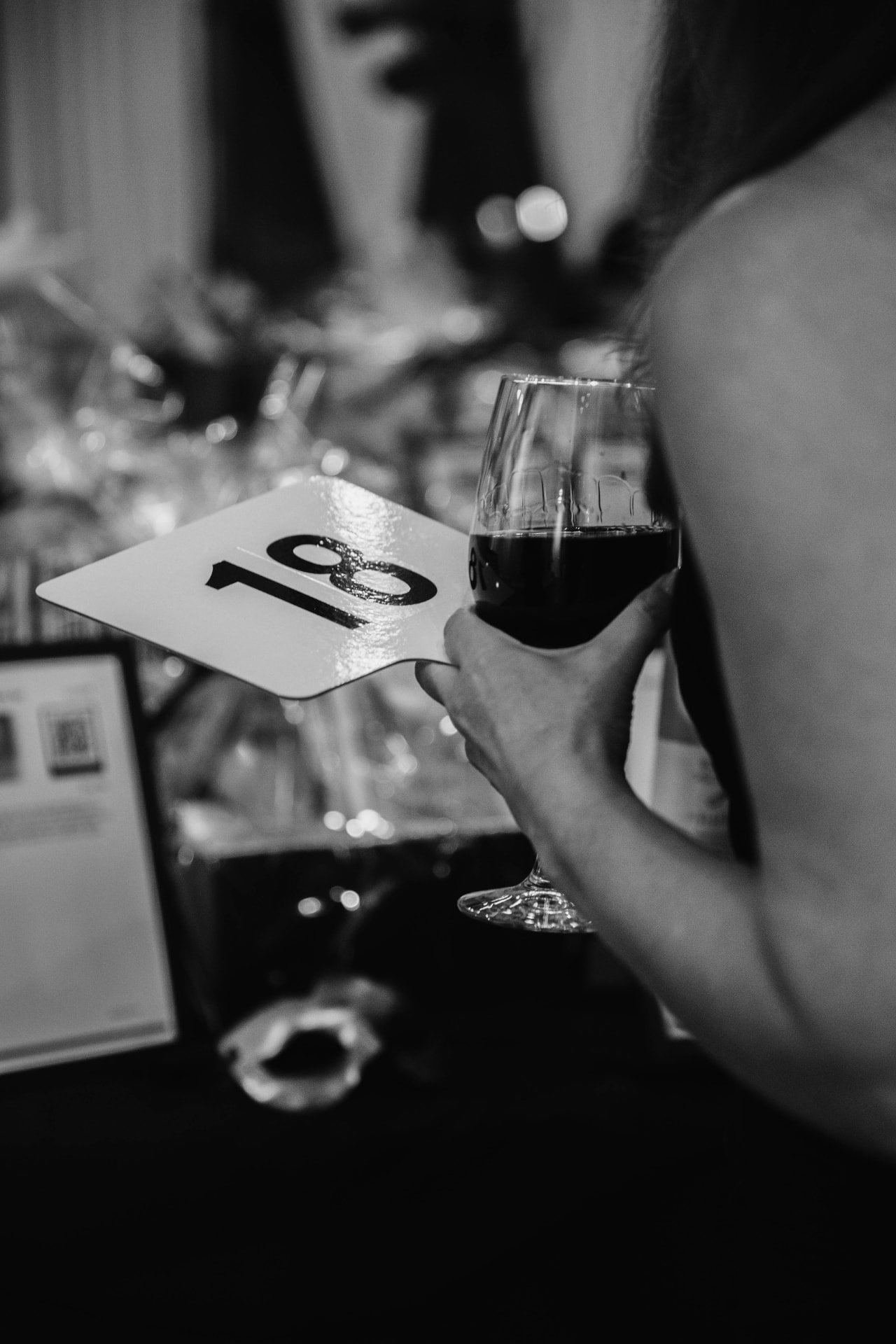 A bidder paddle and a glass of wine held during the evening auction.