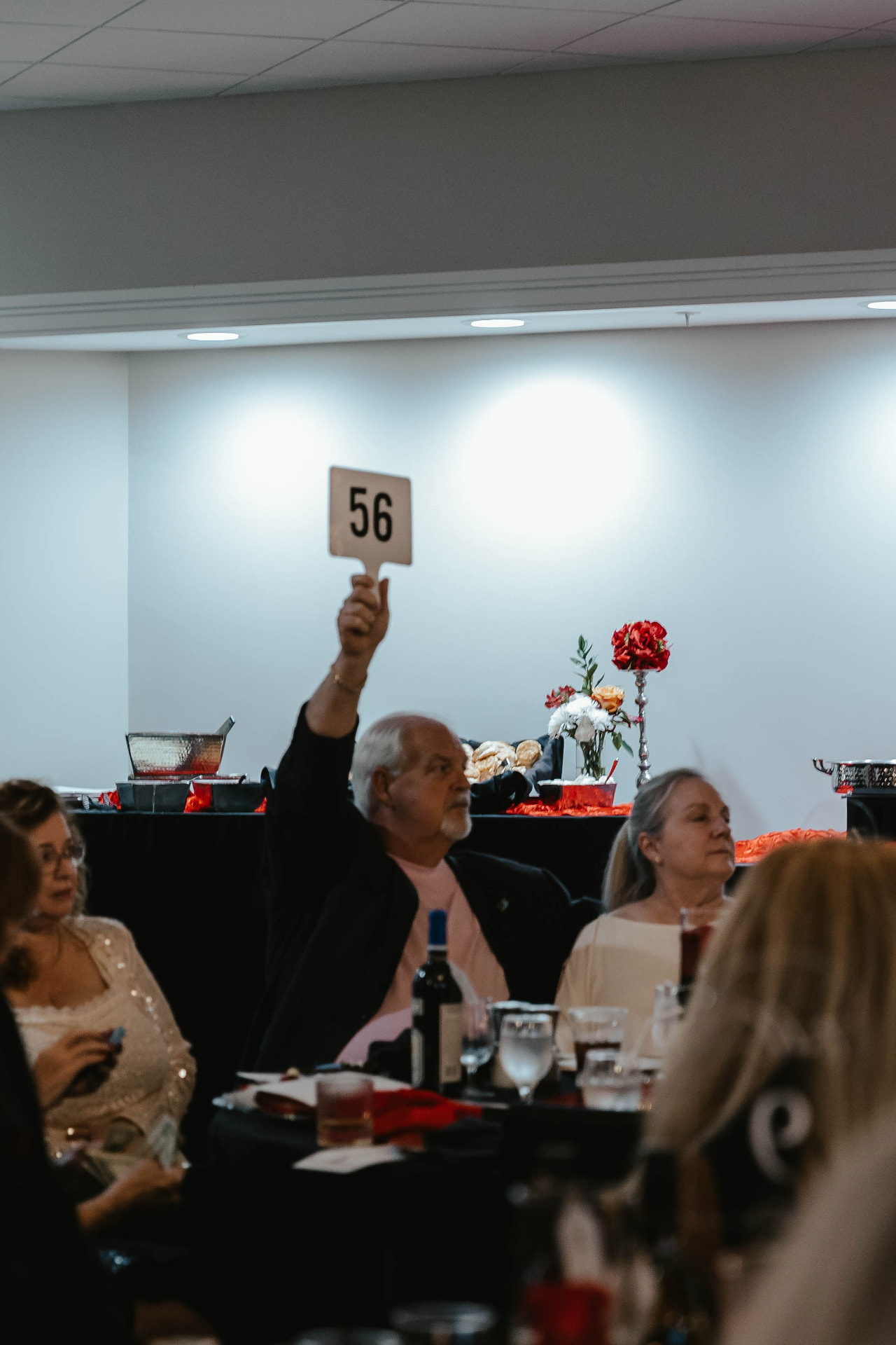 A guest raising a bidder paddle during the Lady in Red Gala auction.