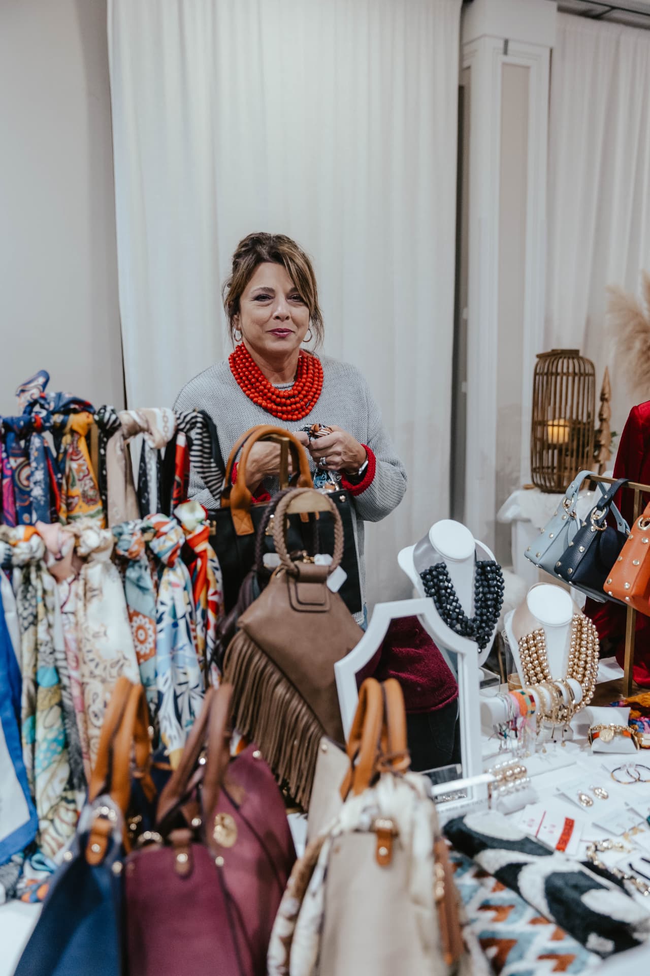 Vendor table with handbags, jewelry and accessories at the Sip & Sparkle Vendor Holiday Market.