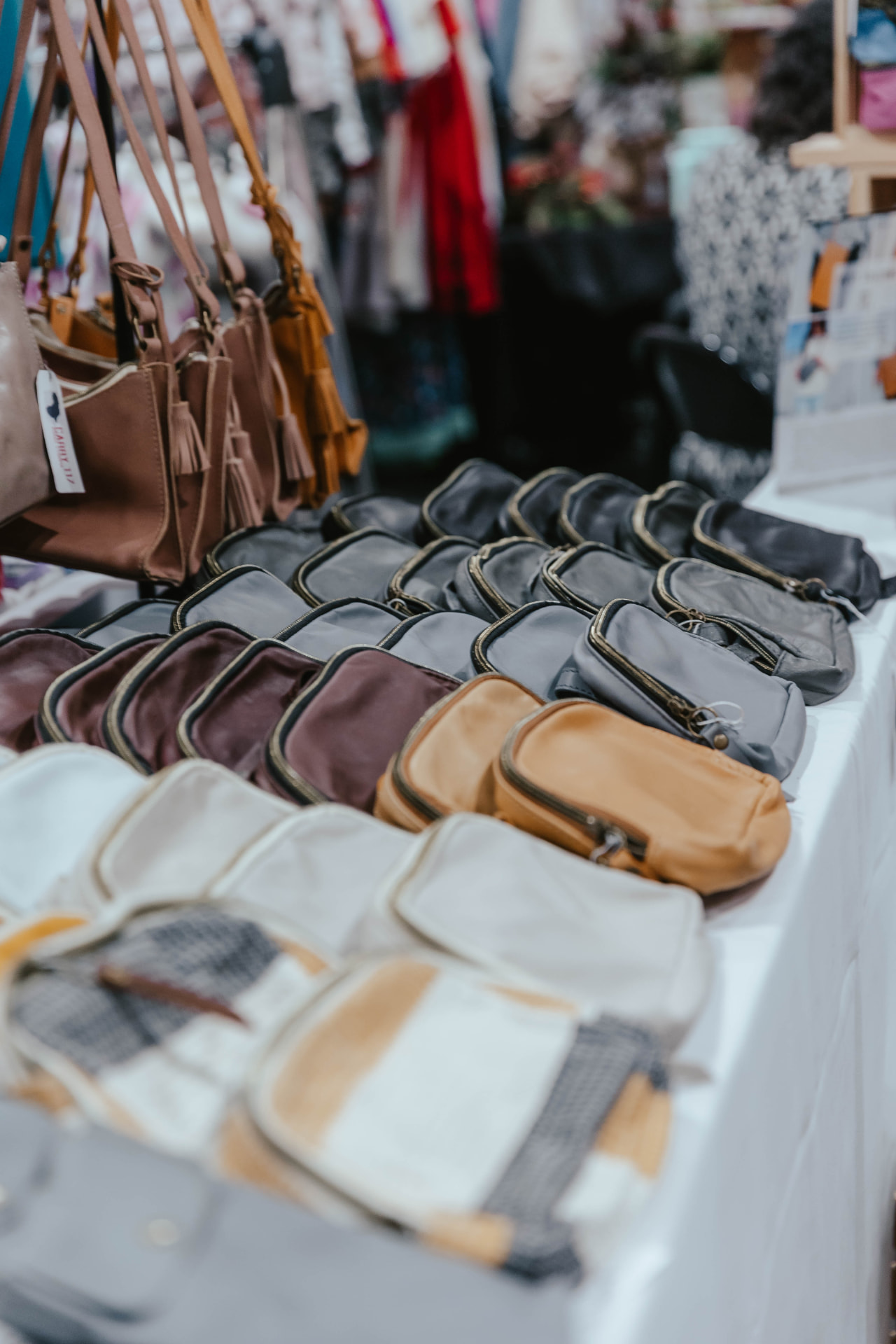 Handbags displayed on a vendor table at the Sip & Sparkle Vendor Holiday Market.