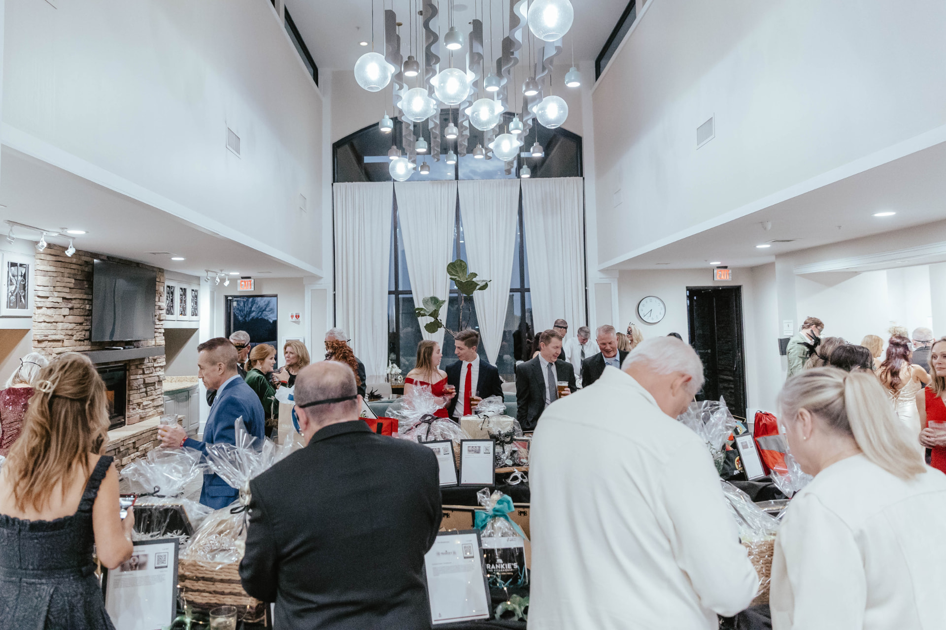 Guests browsing silent auction baskets beneath the ballroom chandeliers.