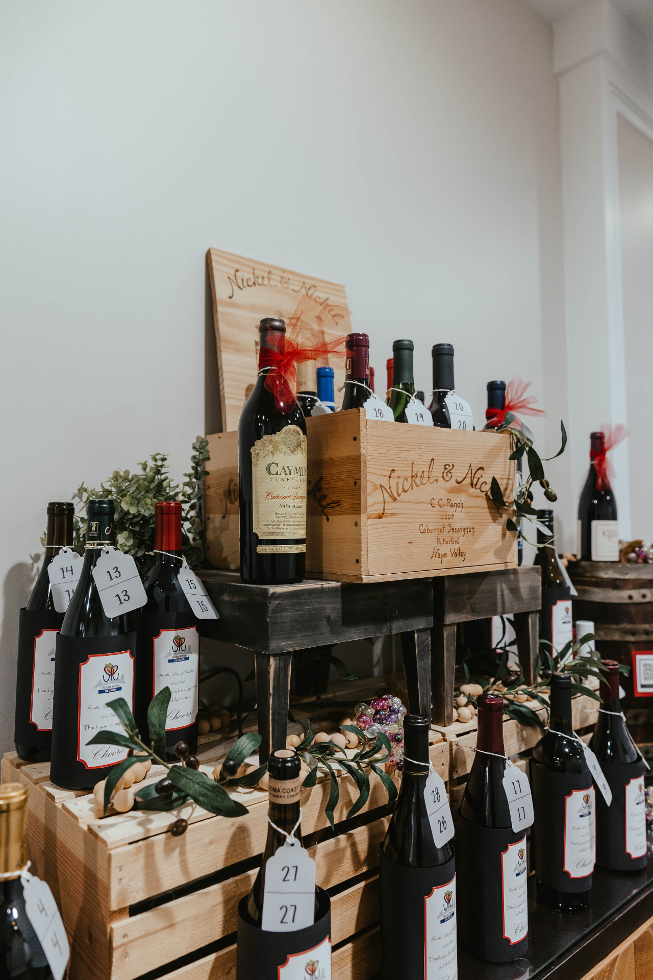 Wine bottles and wooden crates displayed for the Lady in Red Gala auction.
